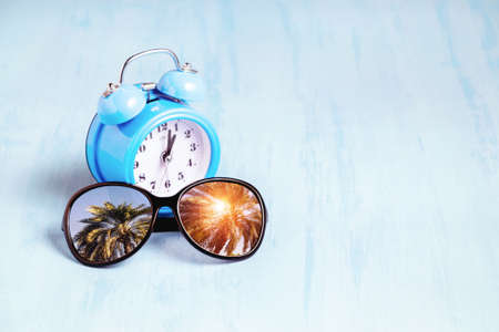 Blue sea background with sunglasses and alarm clocks, summer holiday and vacation time concept