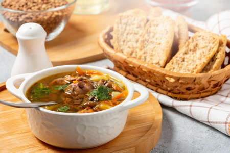 Lentil soup with chicken in a white bowl on a wooden boardの写真素材