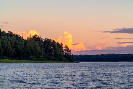Beautiful clouds over the lake at sunset on a summer dayの写真素材