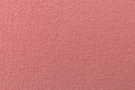 surface of the plastered wall painted in coral color-trendy color of 2019 year