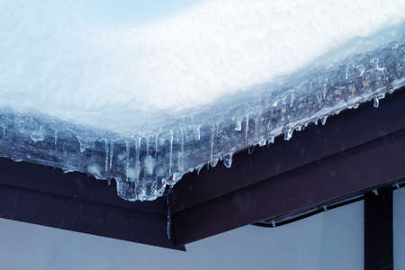 lot of snow on the roof of a rural cottage
