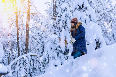 with a  in her hands is walking in  snowy winter forest