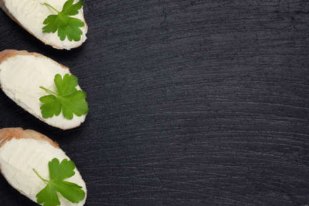 Sandwiches with cream cheese on a dark slate board - template for design with place for textの写真素材