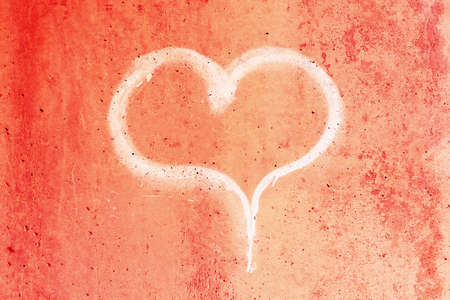 Heart drawn in chalk on a red concrete wall