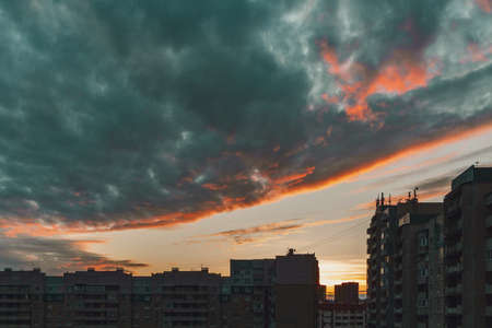 Beautiful dawn over city houses, dramatic clouds, backgroundの写真素材