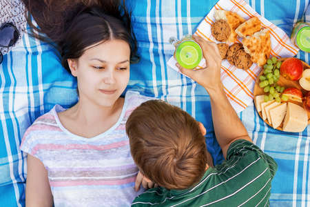 Young loving couple resting on a picnic on a summer dayの写真素材
