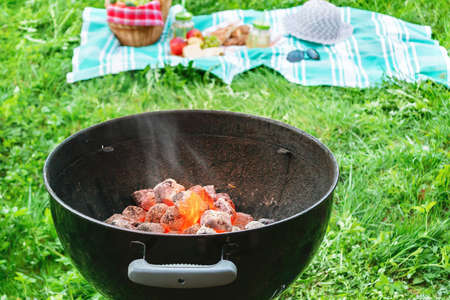 Almost ready to cook embers in a round grill at a picnic on an outdoor patioの写真素材