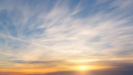 Cirrus and cumulus clouds in the blue sky before sunset