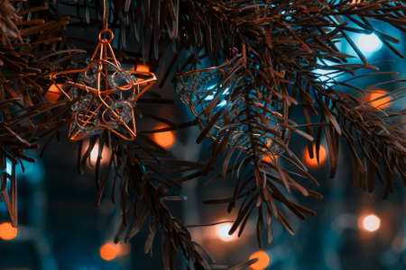Christmas composition, decorations on the branches of a Christmas tree on a dark background with lightsの写真素材