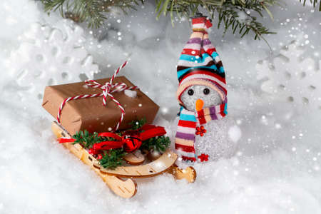 Christmas composition under the Christmas tree - a snowman, boxes with gifts on a sled and other decorations, place for text, copy spaceの写真素材