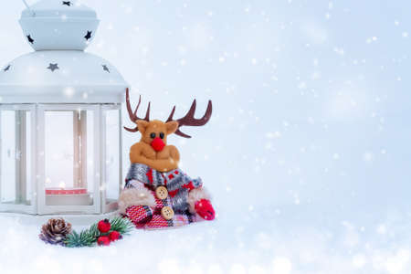Christmas composition - deer, lantern with a burning candle and decorations under the Christmas treeの写真素材