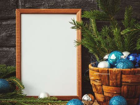 Christmas composition - a wooden frame for text and a basket with fir branches and decorationsの写真素材