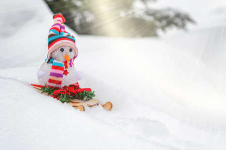 Snowman slides downhill on a sled - winter and Christmas fun concept, place for text, copy spaceの写真素材