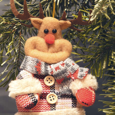 Fabric toy deer on Christmas tree on Christmas eveの写真素材
