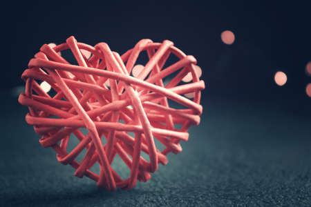 Romantic composition - one wicker heart a symbol of love on a dark table. Valentines day conceptの写真素材