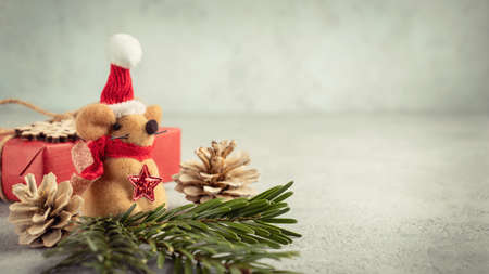 Little toy Christmas mouse, gift and decorations on a gray table. Christmas composition with the symbol of 2020 according to the Chinese horoscopeの写真素材