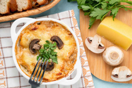 Casserole with chicken, mushrooms and cheese, known in Russia as julienne in white bowl with herbs, top view, flat layの写真素材