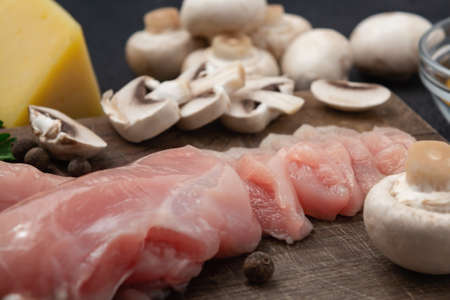 Slicing chicken breast fillet for cooking with champignons and cheeseの写真素材