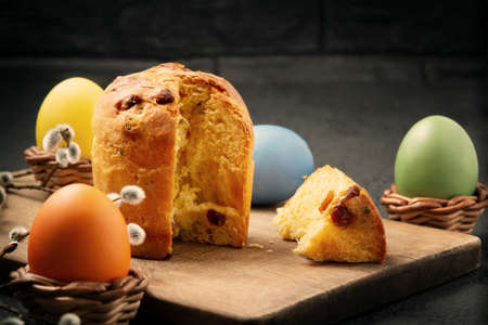 Easter cake on a cutting board and colored eggs - traditional easter breakfast