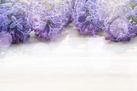 Beautiful floral blank for design - a border of lilac flowers on a wooden table with copy space for...