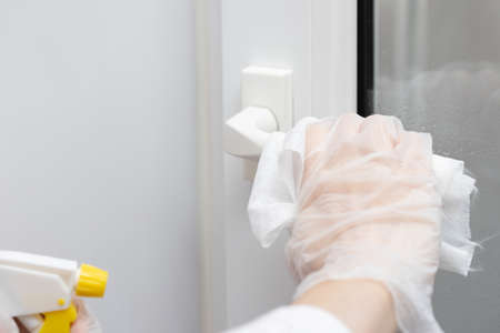 Actions to prevent the spread of coronavirus KOVID-19, disinfection of the door handle. Hand in...