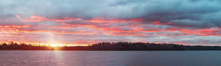 Colorful sunset with dramatic clouds on the lake. Panoramic landscapeの写真素材