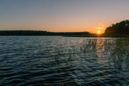 Setting sun on a lake on a summer evening - beautiful landscapeの写真素材