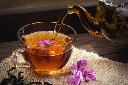 Pouring fireweed herbal tea into a transparent cupの写真素材