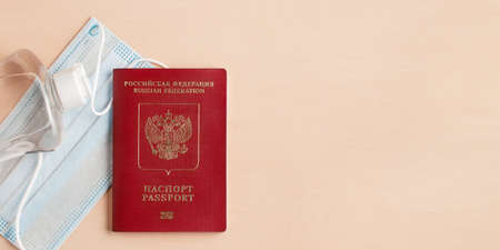 Safe travel during  pandemic concept. Protective medical mask, sanitizer and Russian passport on the table, copyspace, flatlayの写真素材