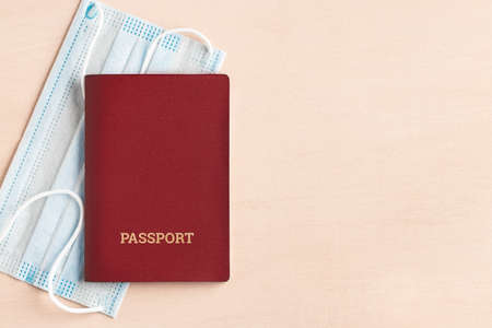 Safe travel during  pandemic concept. Protective medical mask and passport on the table, copyspace, flatlayの写真素材