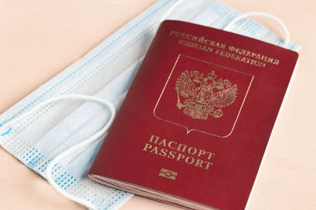 Safe travel during  pandemic concept. Protective medical mask and Russian passport on the tableの写真素材
