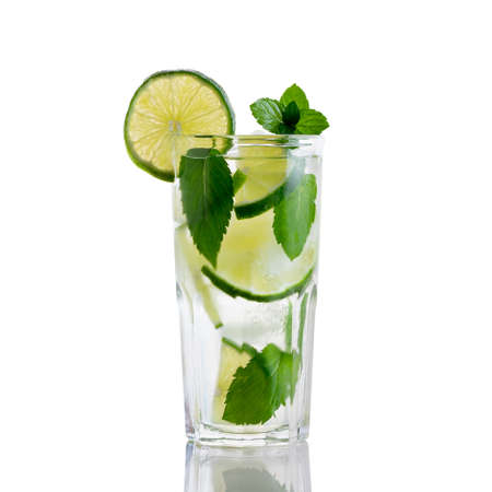 Fresh homemade mojito cocktail in a tall glass with lime, mint and ice isolated on white backgroundの写真素材