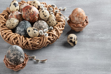 Easter composition - several marble eggs painted with natural dyes in a wicker nest and baskets, top view, copy space.の写真素材