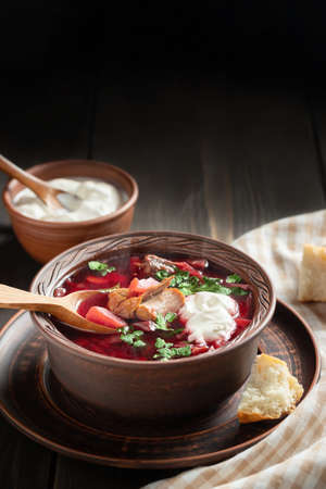 Freshly cooked borscht - traditional dish of Russian and Ukrainian cuisine in earthenware dish with...