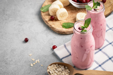 Homemade yogurt smoothie with banana, cranberry and oatmeal, copy spaceの写真素材