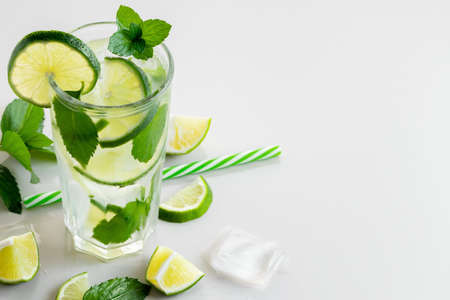 Fresh homemade cocktail with lme, mint and ice on a white table, copy spaceの写真素材