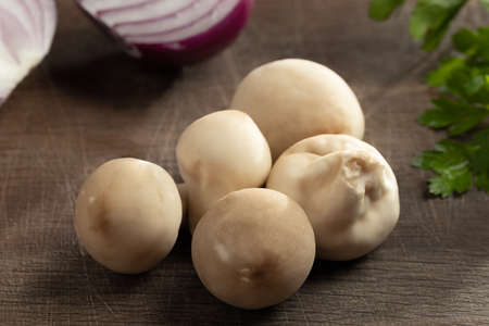 Cooking edible puffball mushrooms. Several whole mushrooms on a cutting boardの写真素材