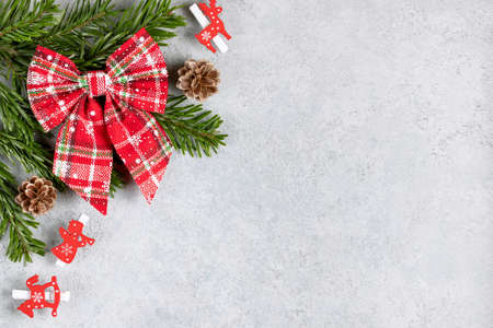 Christmas tree branches with red decorations on a gray table. Template for greeting card or design. Horizontal banner with copy spaceの写真素材