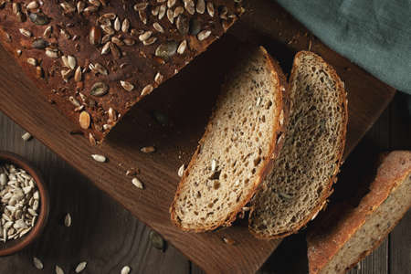 Sliced Homemade Whole Grain Bread with Seeds on a Cutting Boardの写真素材