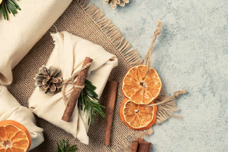 Zero waste christmas concept. Packed in natural fabric gifts and decorations from natural materials on gray table, top viewの写真素材