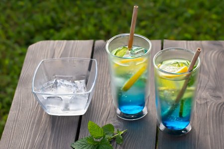 Two glasses with summer cool lagoon cocktail on a wooden table. Selective focusの写真素材
