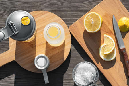 Cooking fresh homemade isotonic from natural ingredients - salt, lemon and mineral water. Top view, flat lay, selective focusの写真素材