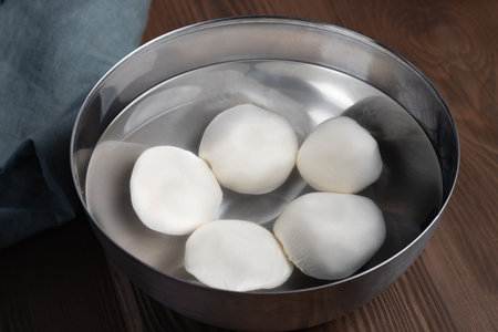 Making mozzarella cheese. Cooling the finished balls in cold waterの写真素材