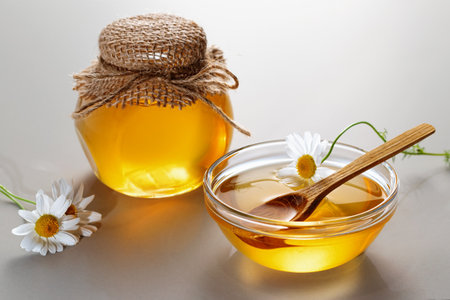 Chamomile syrup in a small bowl and jar on the kitchen tableの写真素材