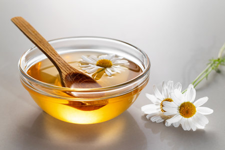 Chamomile syrup in a small bowl and jar on the kitchen tableの写真素材