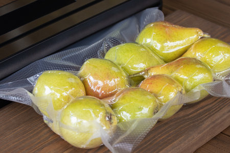 Packing fresh pears with a vacuum packer for long-term storageの写真素材