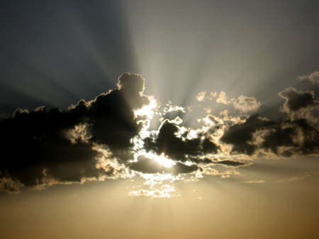 rising sun behind dark clouds 