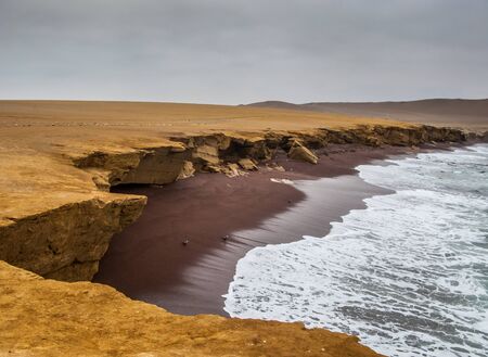 The coast and red sand beach of Paracas National Reserve in Peruの写真素材
