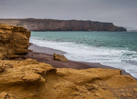 The coast and red sand beach of Paracas National Reserve in Peruの写真素材
