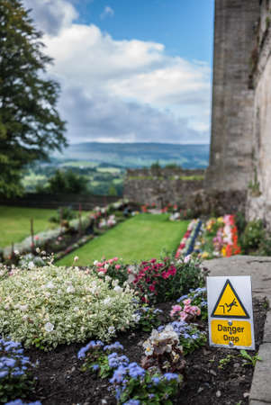 Yellow warning and danger sign in a garden, Scotlandの写真素材